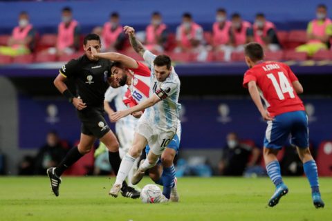 Pemain Argentina Lionel Messi berebut bola dengan pemain Paraguay Alberto Espinola pada pertandingan lanjutan Grup A Copa America 2021 di Estadio Mane Garrincha, Brasilia, Brasil. Foto: Ueslei Marcelino/REUTERS