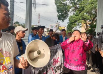 Chotibul Umam Sirait Aktivis Muda yang juga Bendahara PKC PMII Sumatera Utara, saat berunjukrasa di depan Kantor Walikota Pematangsiantar. Foto: Istimewa.