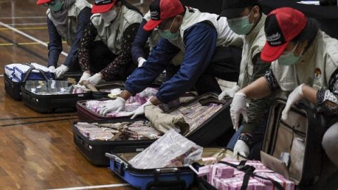 Penyidik KPK menunjukan barang bukti uang tunai saat konferensi pers terkait Operasi Tangkap Tangan (OTT) tindak pidana korupsi pada program bantuan sosial di Kementerian Sosial untuk penanganan COVID-19 di Gedung KPK, Jakarta, Minggu (6/12/2020) dini hari. (Hafidz Mubarak A/Antara Foto