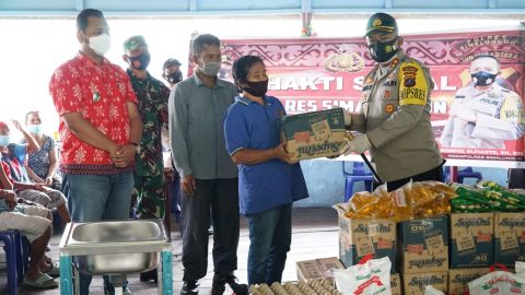 Kapolres Simalungun AKBP Agus Waluyo, S.I.K (kanan) saat memberikan bantuan kepada salah seorang warga di Kampung Tangguh, Kecamatan Sirpang Sipangan Bolon, Jumat (26/02/2021) Foto: Istimewa.