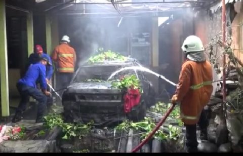 Pemadam kebakaran saat berupaya memadamkan api yang membakar Mobil Milik Edison Tambunan. Foto: Roy.