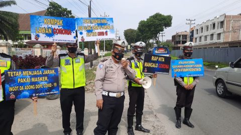 Personil Sat Lantas Polres Simalungun bagikan Masker dan tempelkan Stiker atau Brosur. Foto: Humas Polres Simalungun.