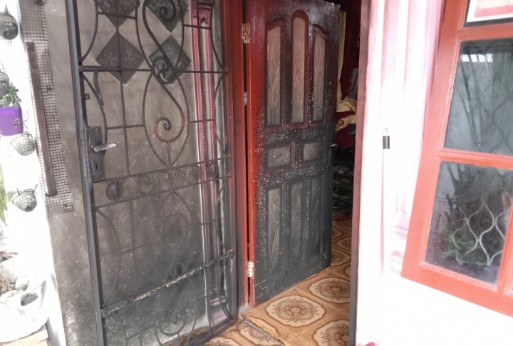 Pintu Rumah yang terbakar Akibat teror lempar bensin oleh OTK. Foto: Redaksi. Sabtu, (29/05/2021).