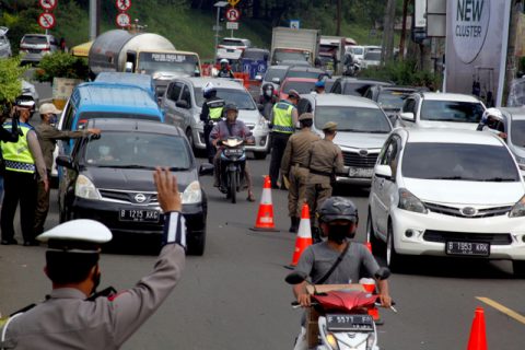 Petugas gabungan Satgas COVID-19 memeriksa surat keterangan tes cepat Antigen wisatawan di jalur wisata Puncak, Gadog, Kabupaten Bogor, Jawa Barat, Selasa (1/6). Foto: Yulius Satria Wijaya/ANTARA FOTO