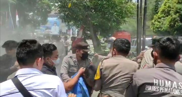 Polisi Polres Pematang Siantar saat ricuh dengan pengunjukrasa, hingga ditembakkannya diduga Gas Air Mata. Foto: Tangkapan layar video ricuh.