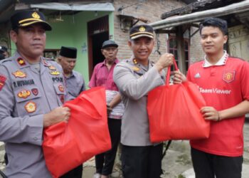 Kapolres Pematang Siantar saat Door to Door memberikan bansos kepada Masyarakat. Foto: Istimewa.