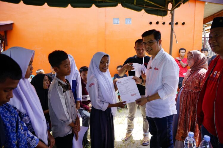 Bane Raja Manalu Staf Khusus Menteri Hukum dan HAM membagikan beasiswa Program Indonesia Pintar (PIP). Foto: Dok. Istimewa.