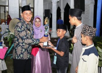 Azka Alfarizha Lubis saat menerima Piala dan penghargaan Juara 1 Lomba MTQ ke 56, Kecamatan Siantar Martoba. Foto: Istimewa.