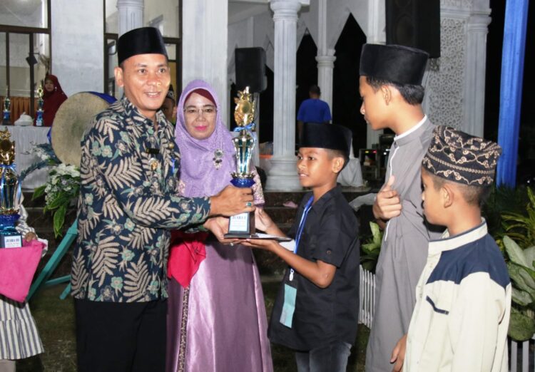 Azka Alfarizha Lubis saat menerima Piala dan penghargaan Juara 1 Lomba MTQ ke 56, Kecamatan Siantar Martoba. Foto: Istimewa.